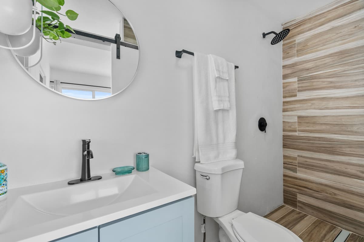 Modern en-suite bathroom with rain shower and natural touches