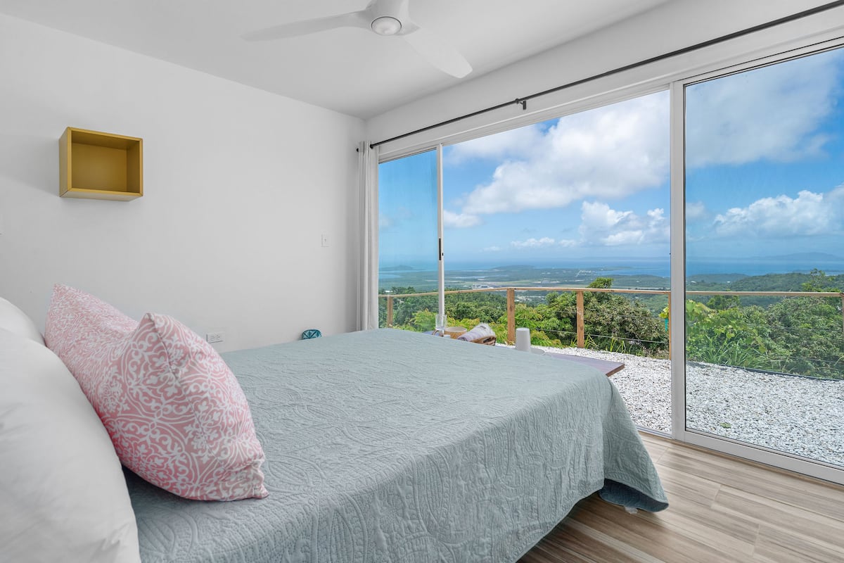 Bright casita bedroom with ocean views through floor-to-ceiling glass doors