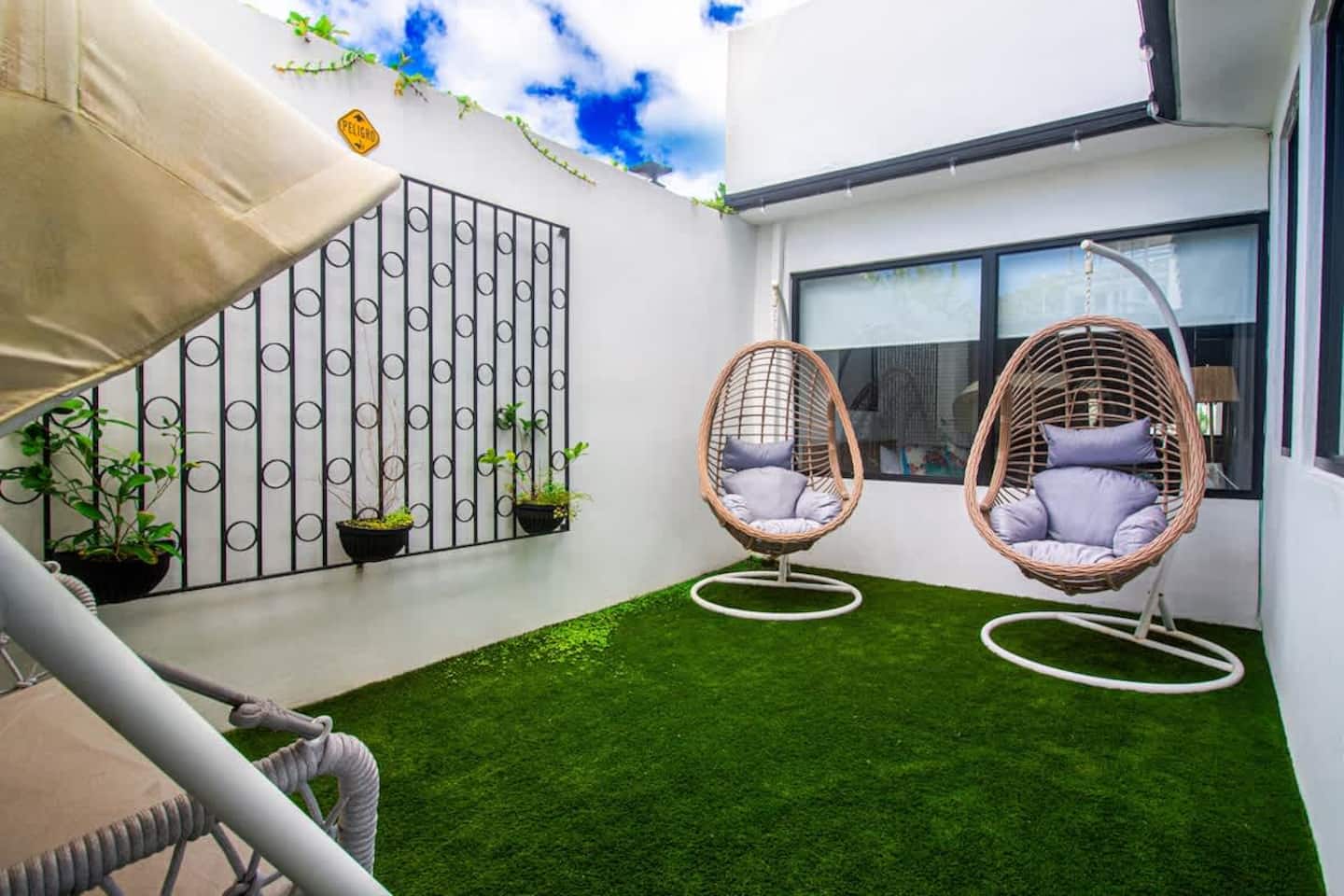 Tranquil interior courtyard with hanging egg chairs and a love seat swing